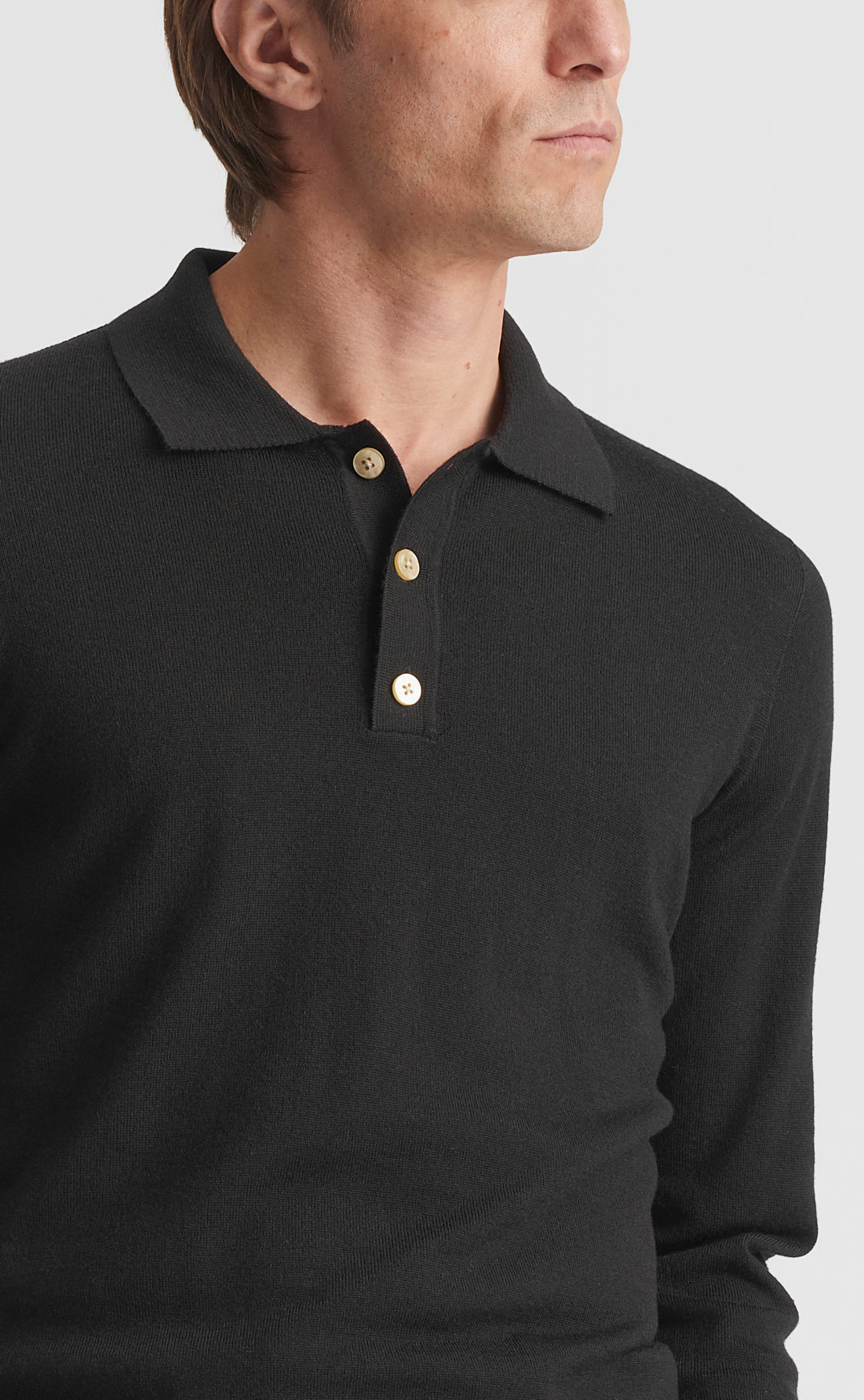 Close-up of the Son of a Tailor Merino Polo Pullover collar and three-button placket in black