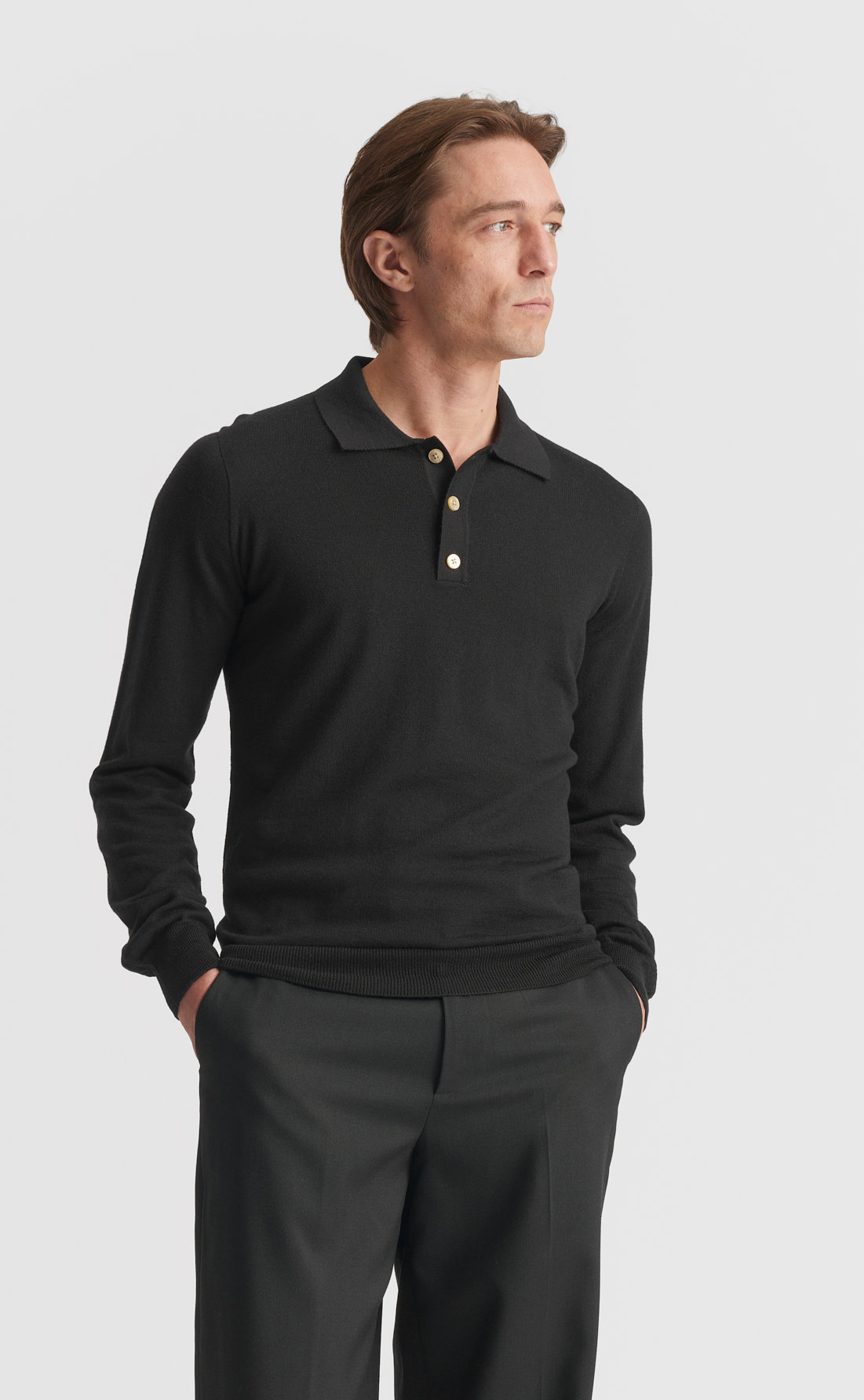 Son of a Tailor Merino Polo Pullover in black, three-quarter view with hands in pockets