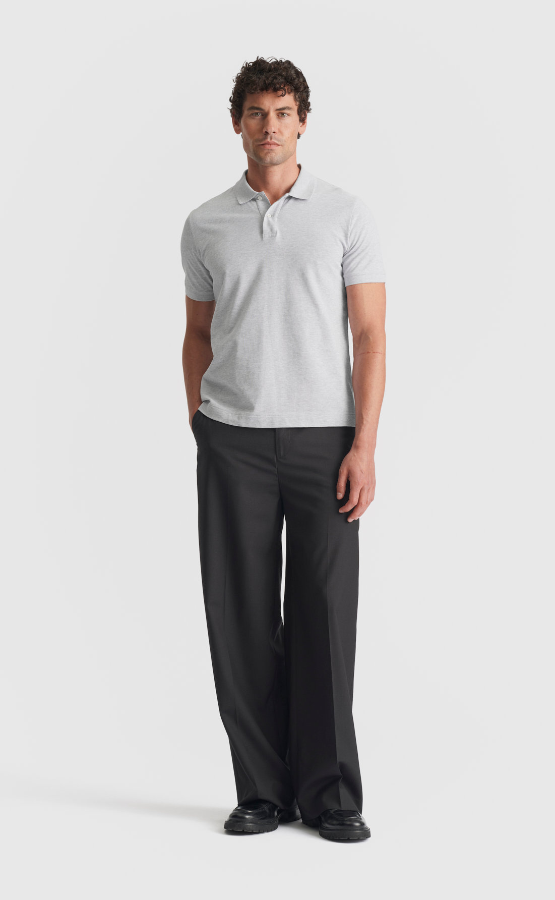grey dress pants with polo shirt Men's light grey tailored pants, light blue knitted polo shirt and brown double monk-strap shoes