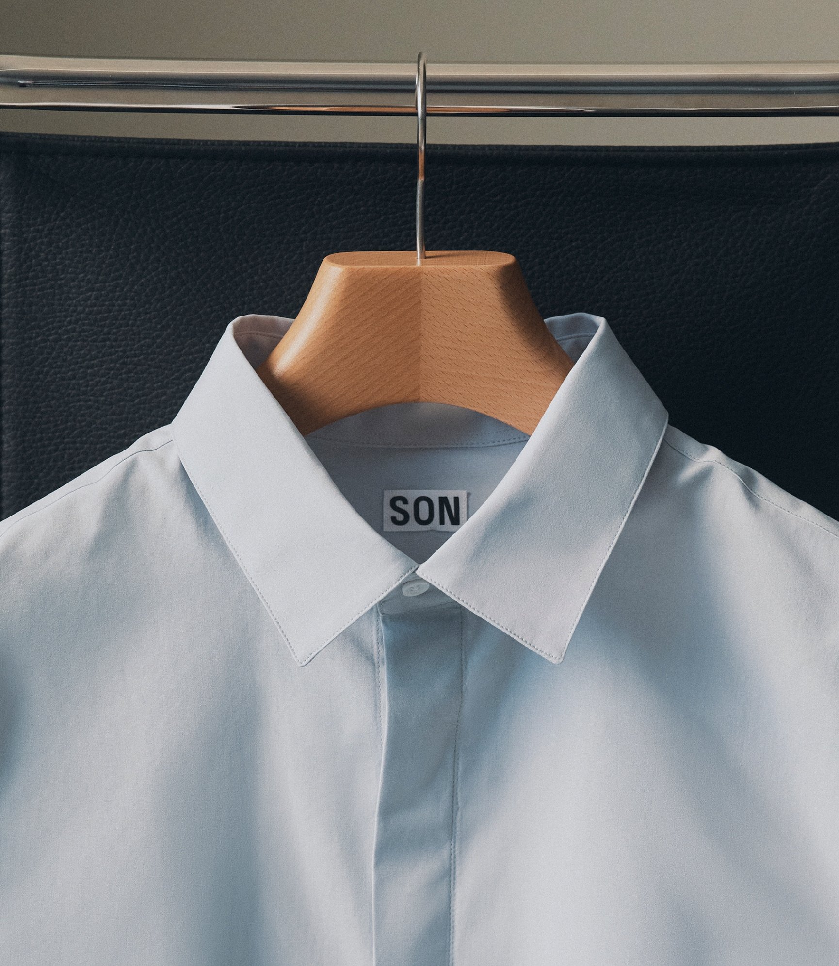 Close-up of a pale blue shirt collar on a hanger