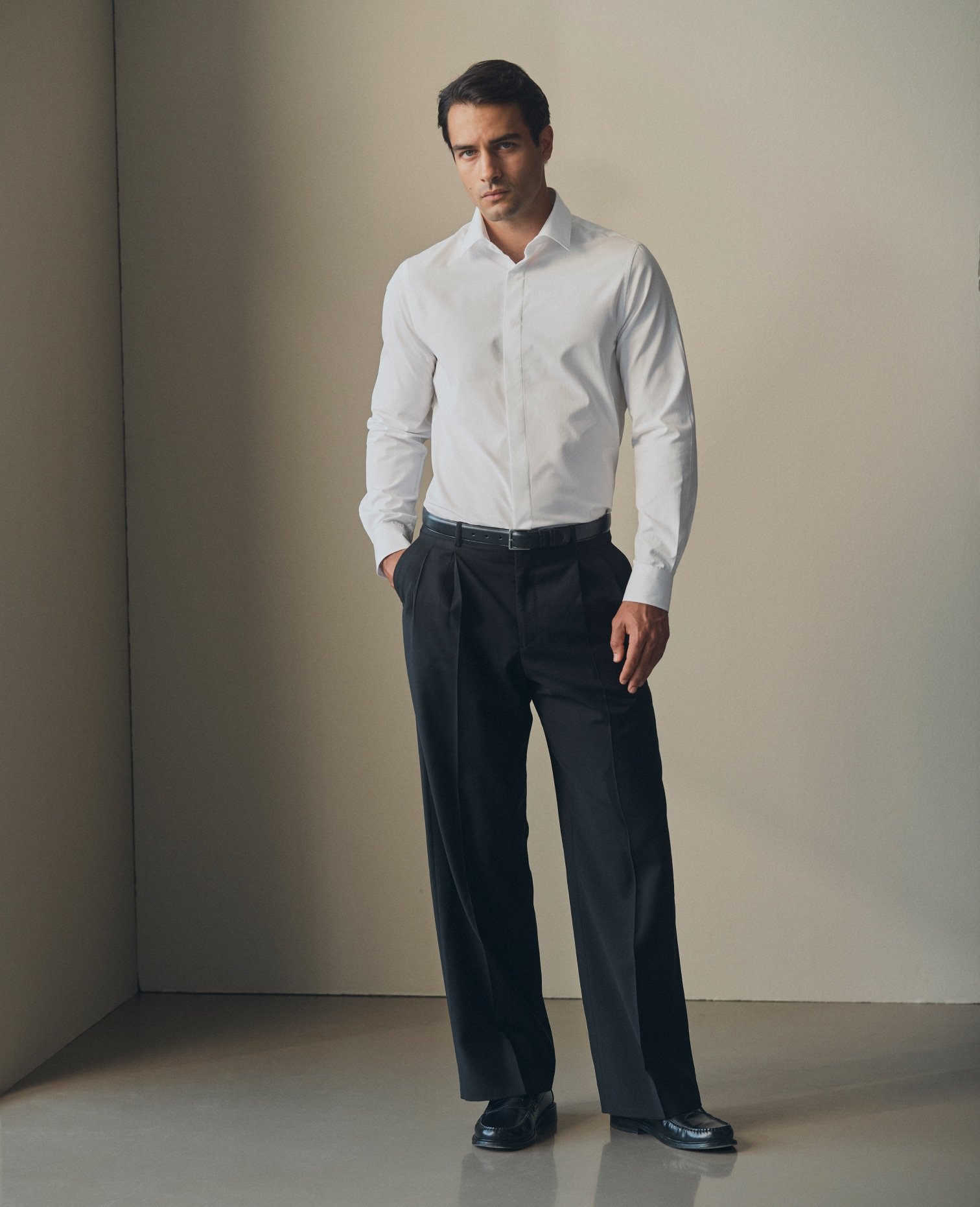 Model in a white shirt and dark tailored trousers
