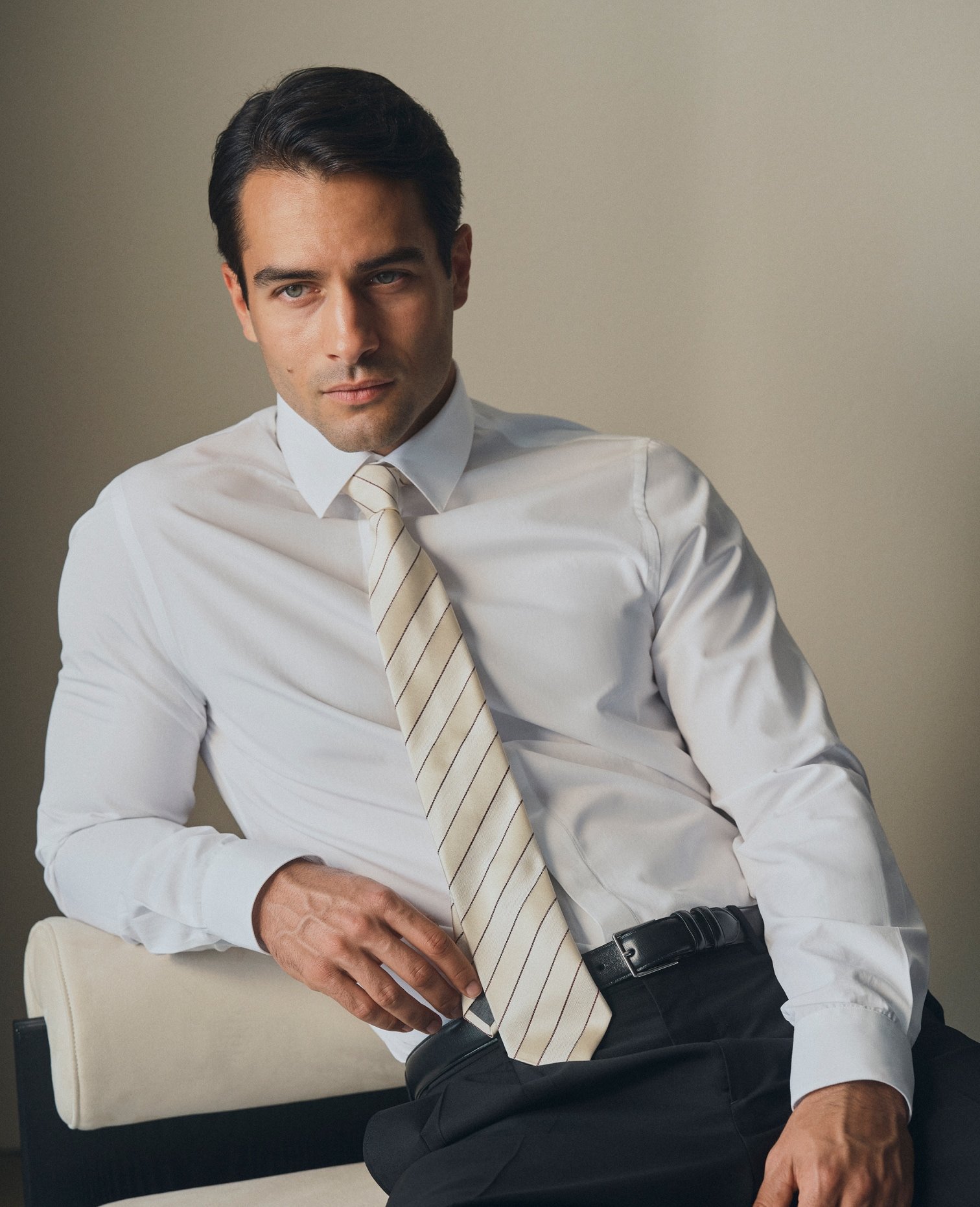 Model in a white shirt with an untied striped tie