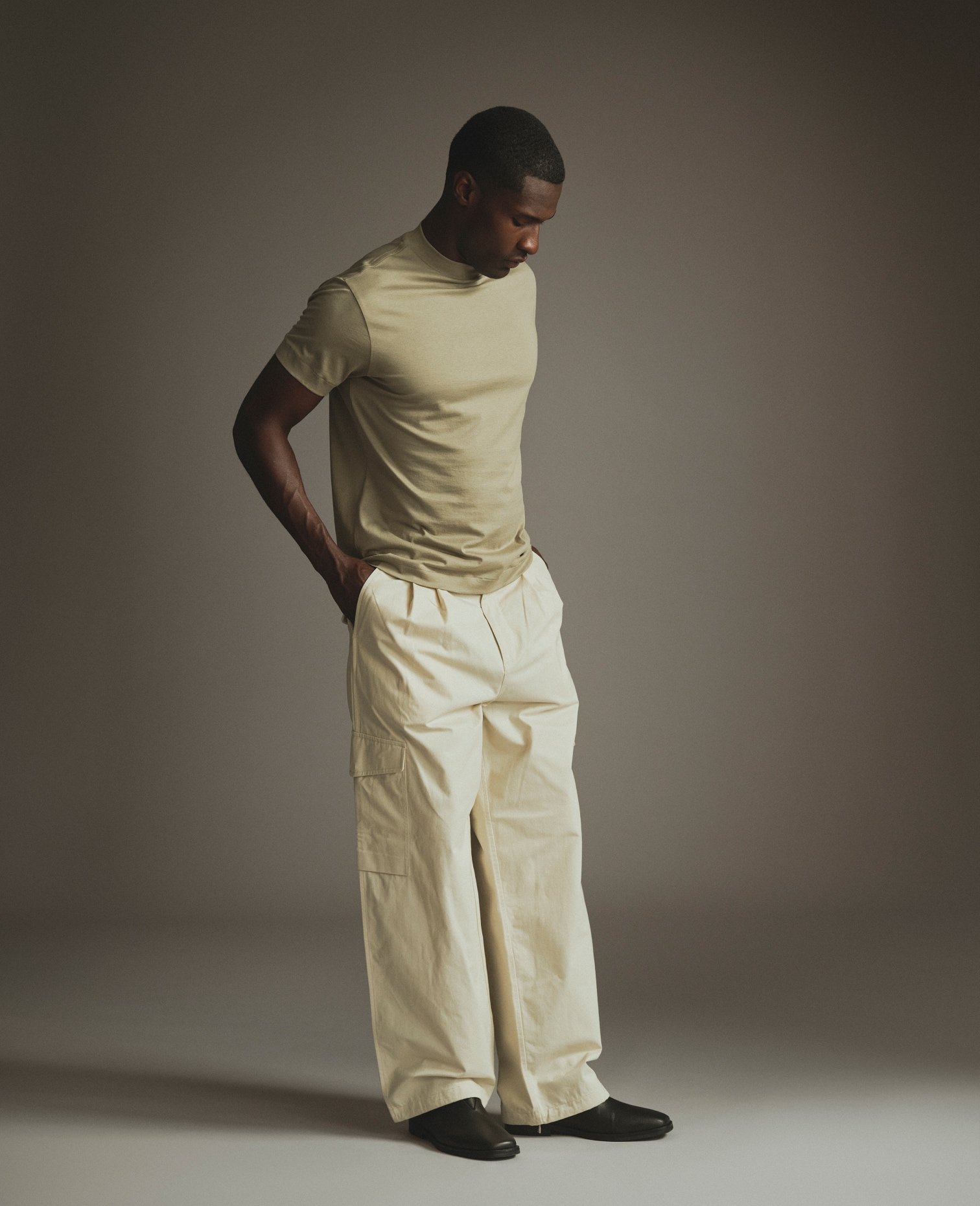 Model in a cream T-Shirt and wide-leg off-white trousers