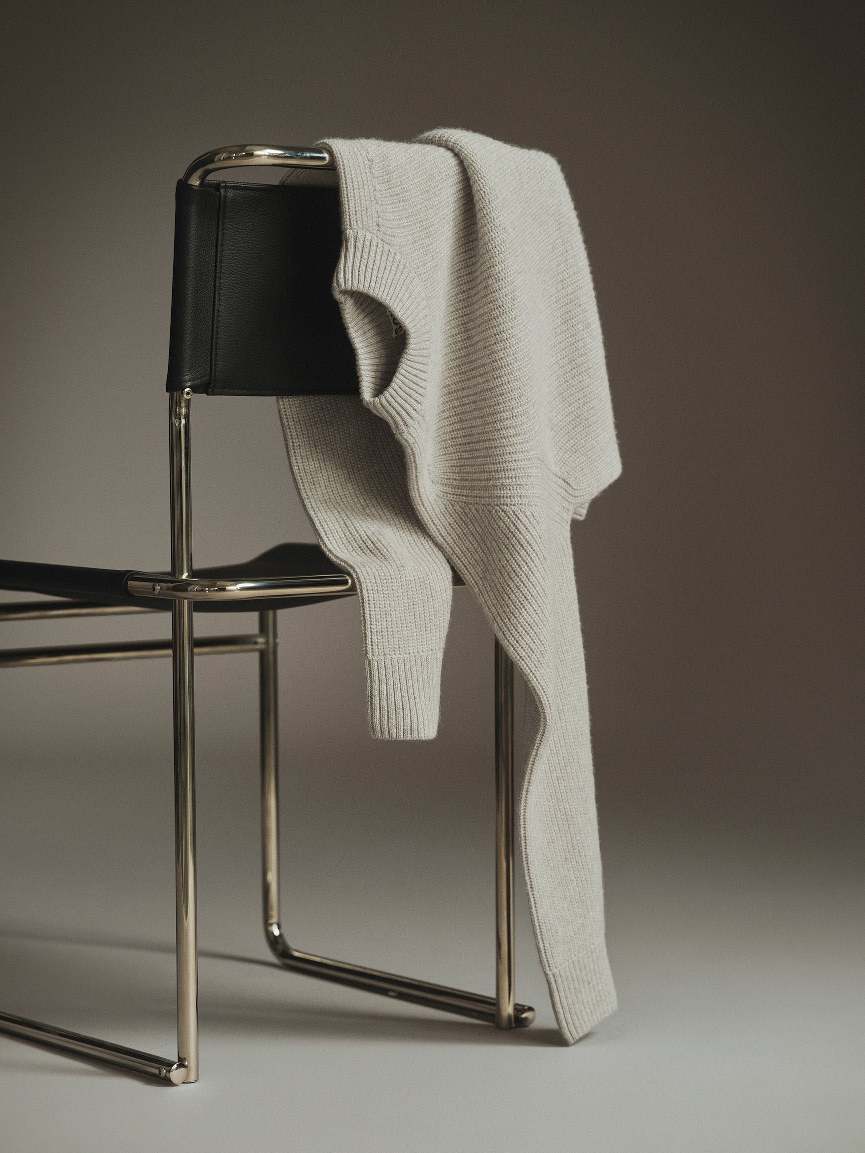 Cream ribbed knit draped over a chrome-framed chair