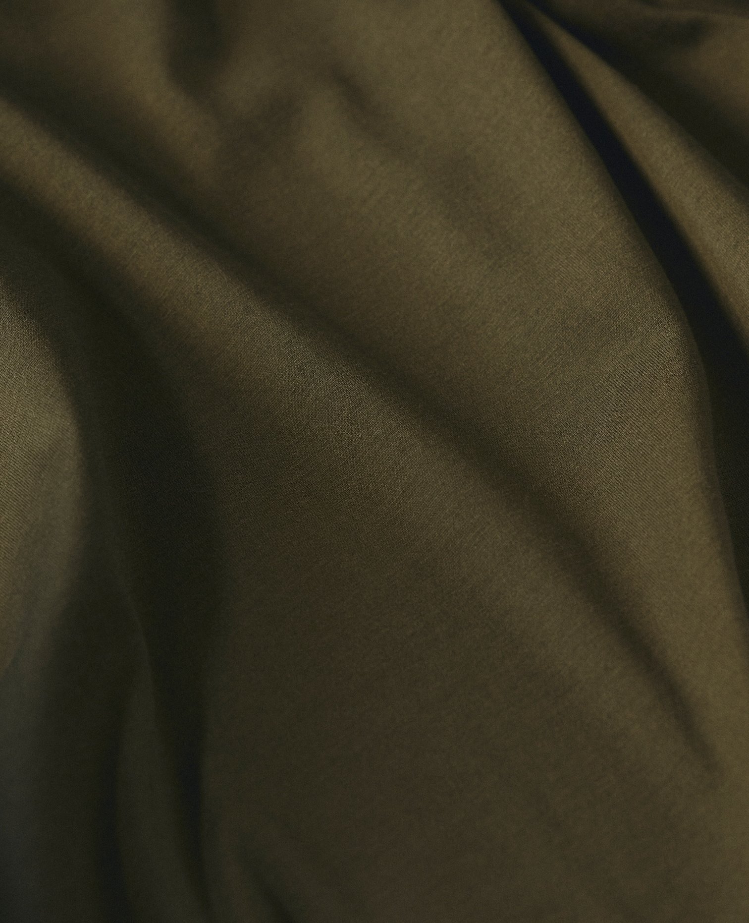 Close-up of olive green fabric falling in soft folds