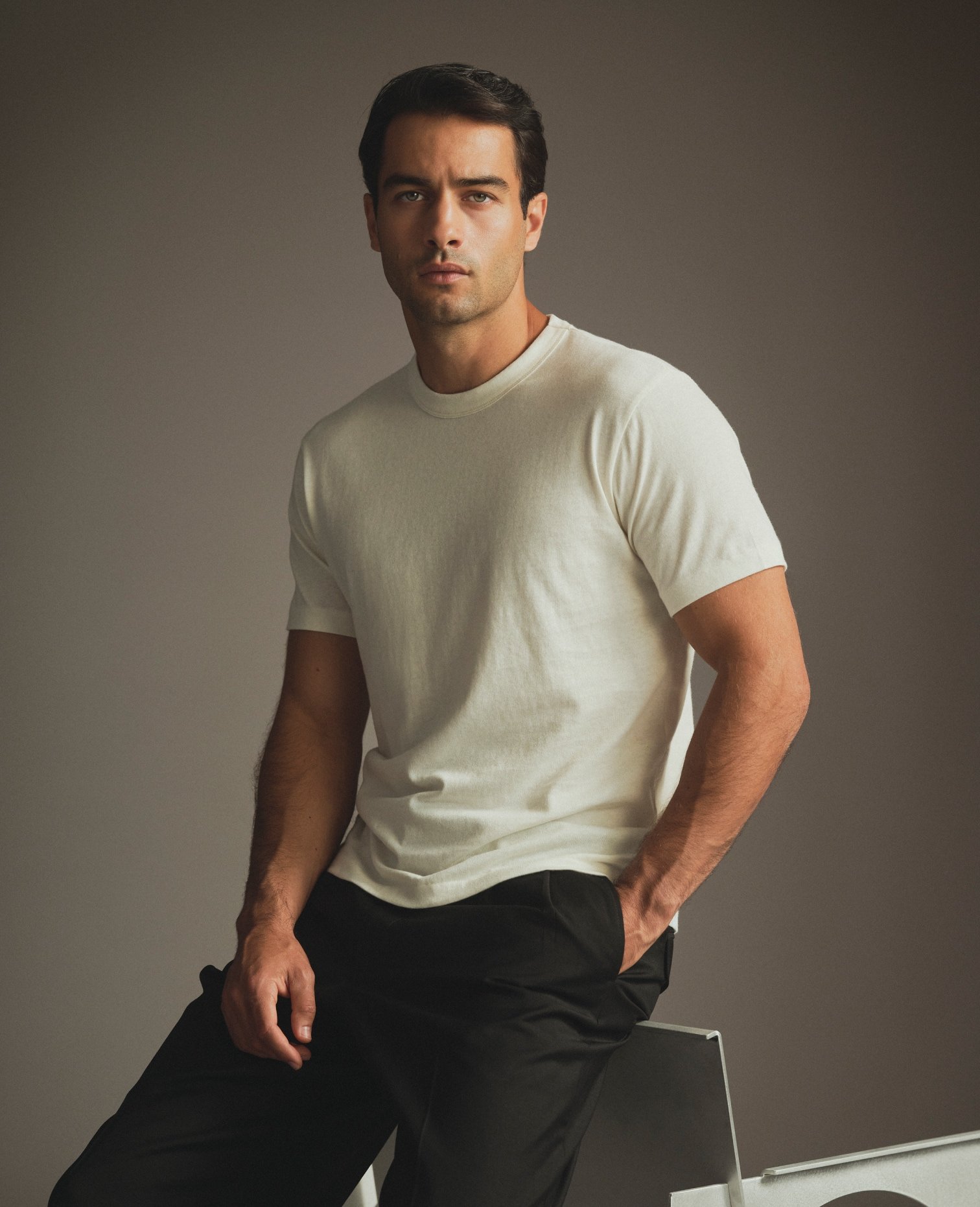 Model in an off-white T-Shirt and black trousers