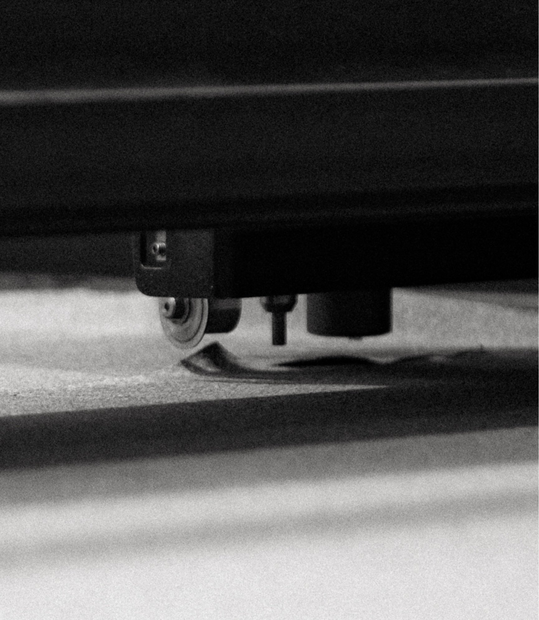 Detail of the base of an industrial sewing machine in black and white