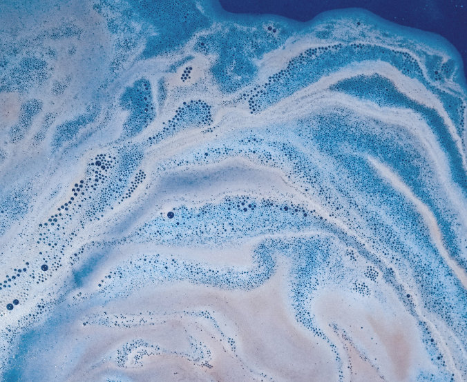 Aerial view of blue and white foam swirling on water