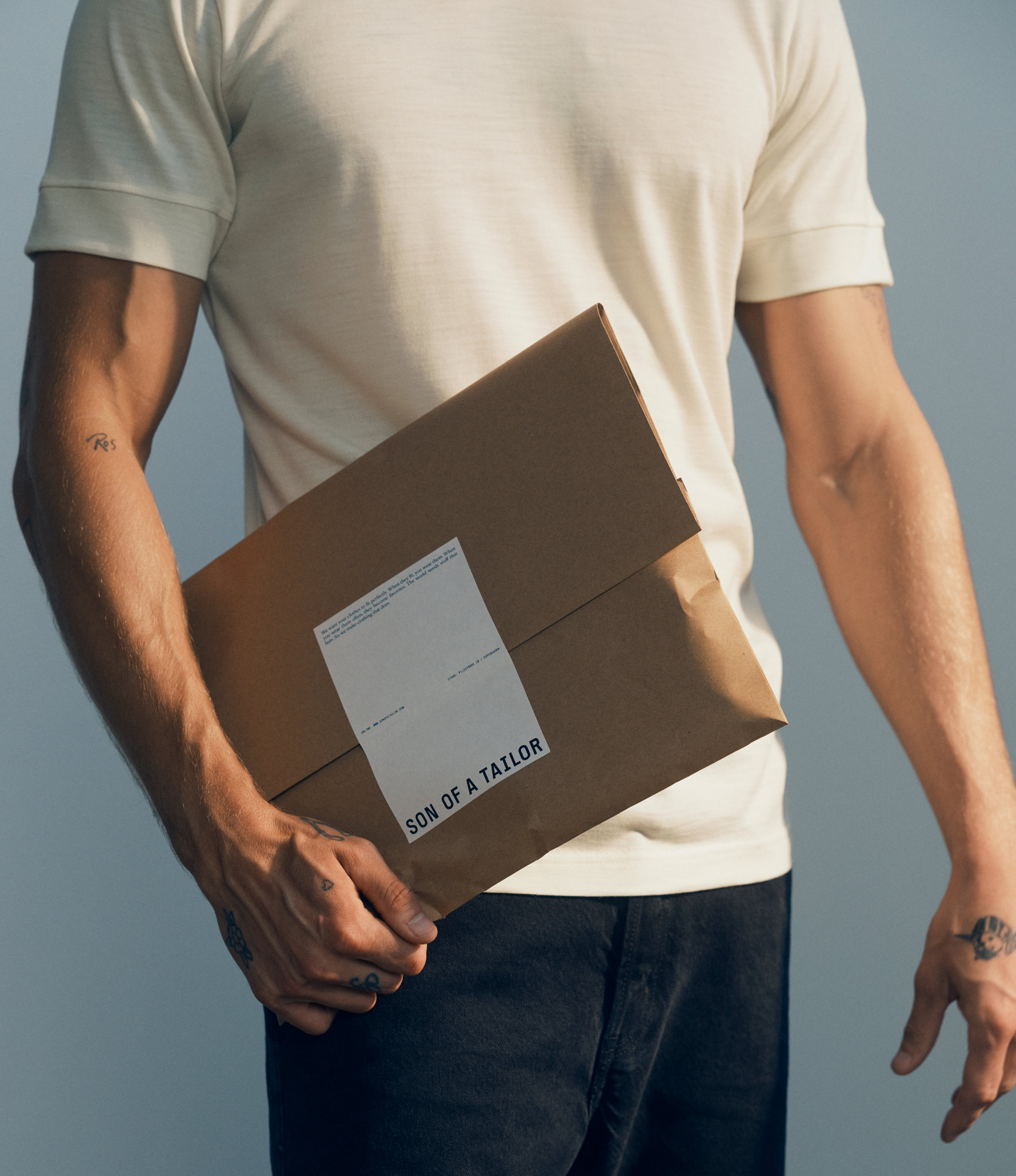 Man holding a Son of a Tailor parcel