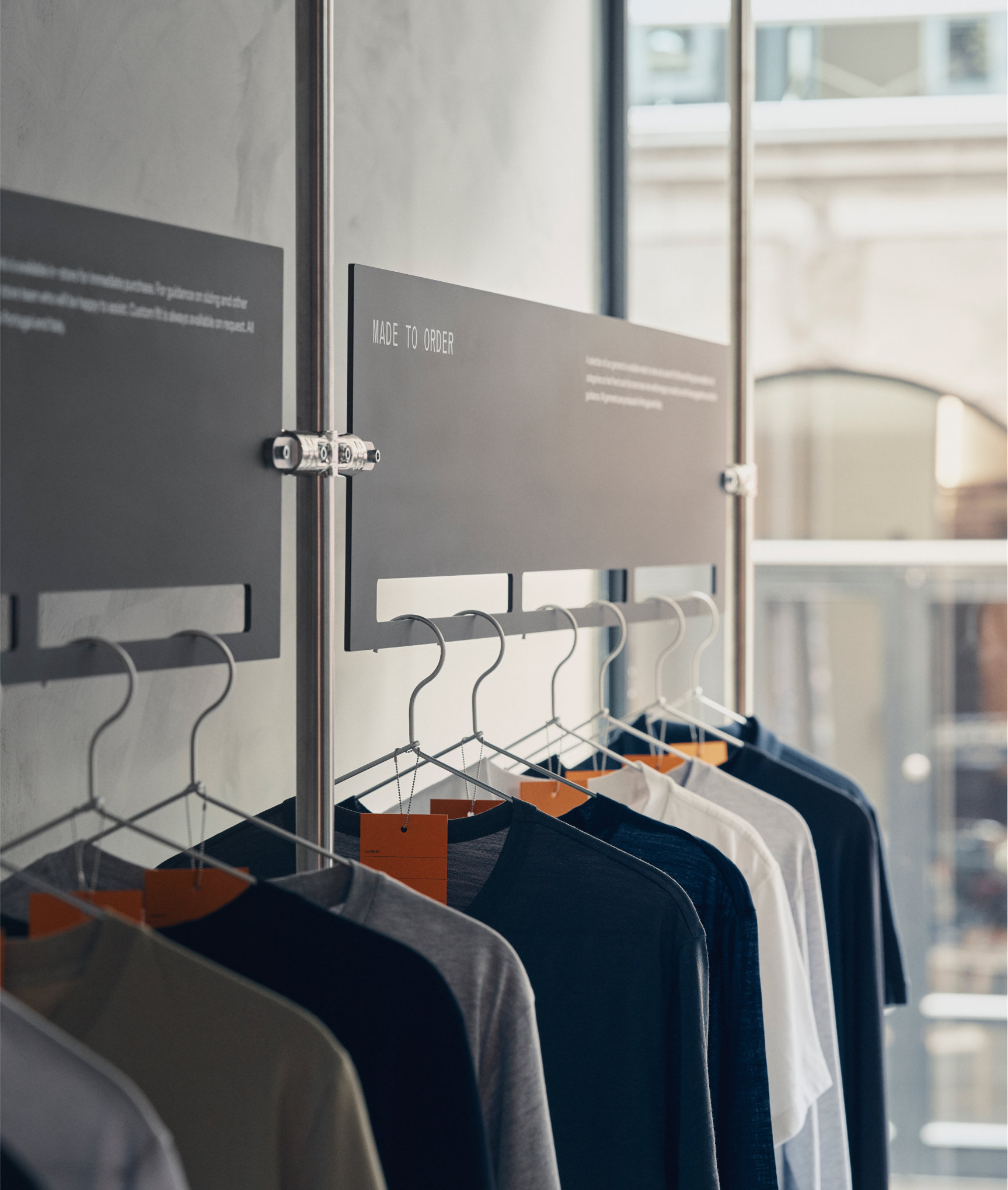 T-shirts in neutral colors displayed beneath a Made to Order sign