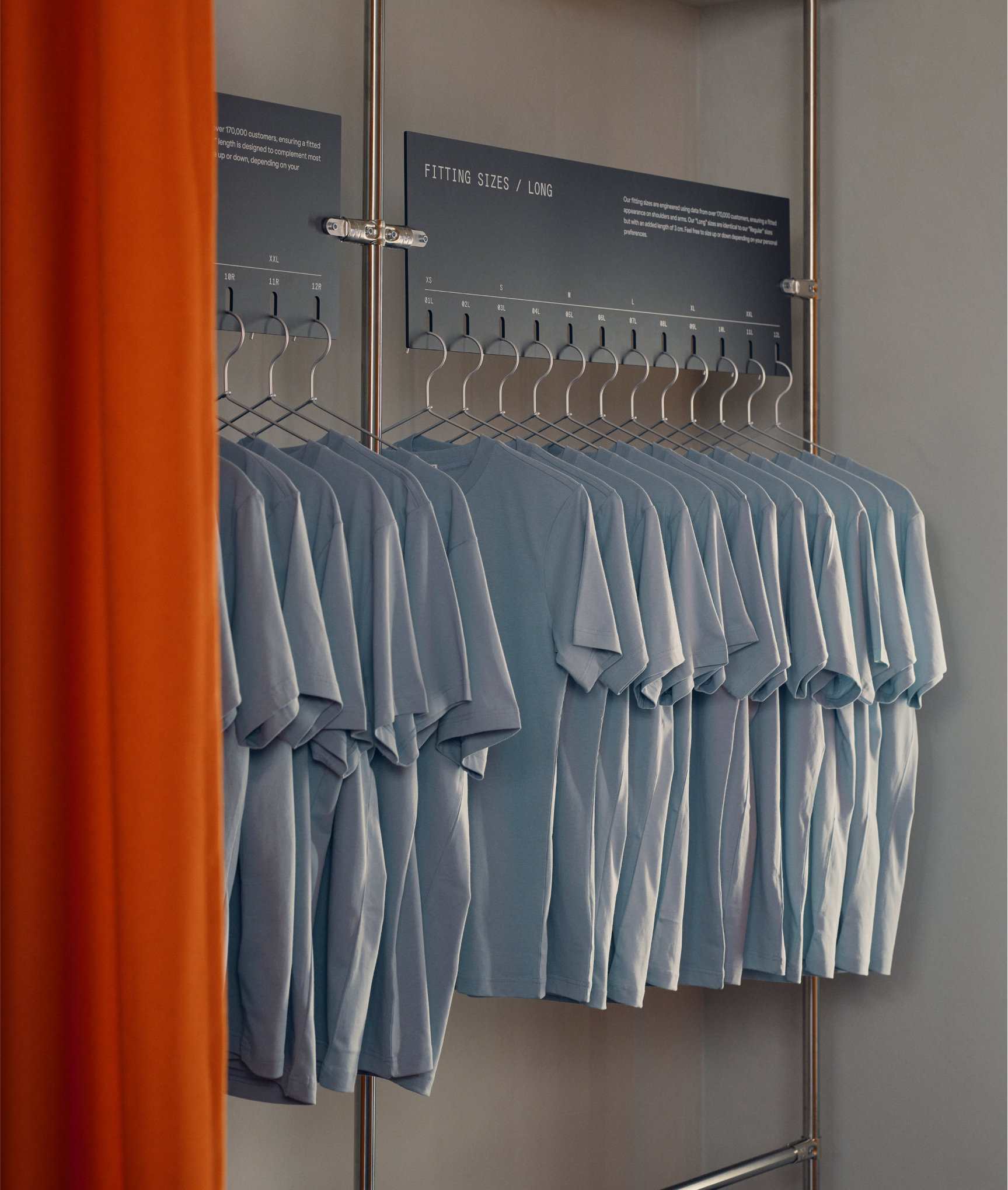 Light blue fitting T-shirts arranged by size on a rail