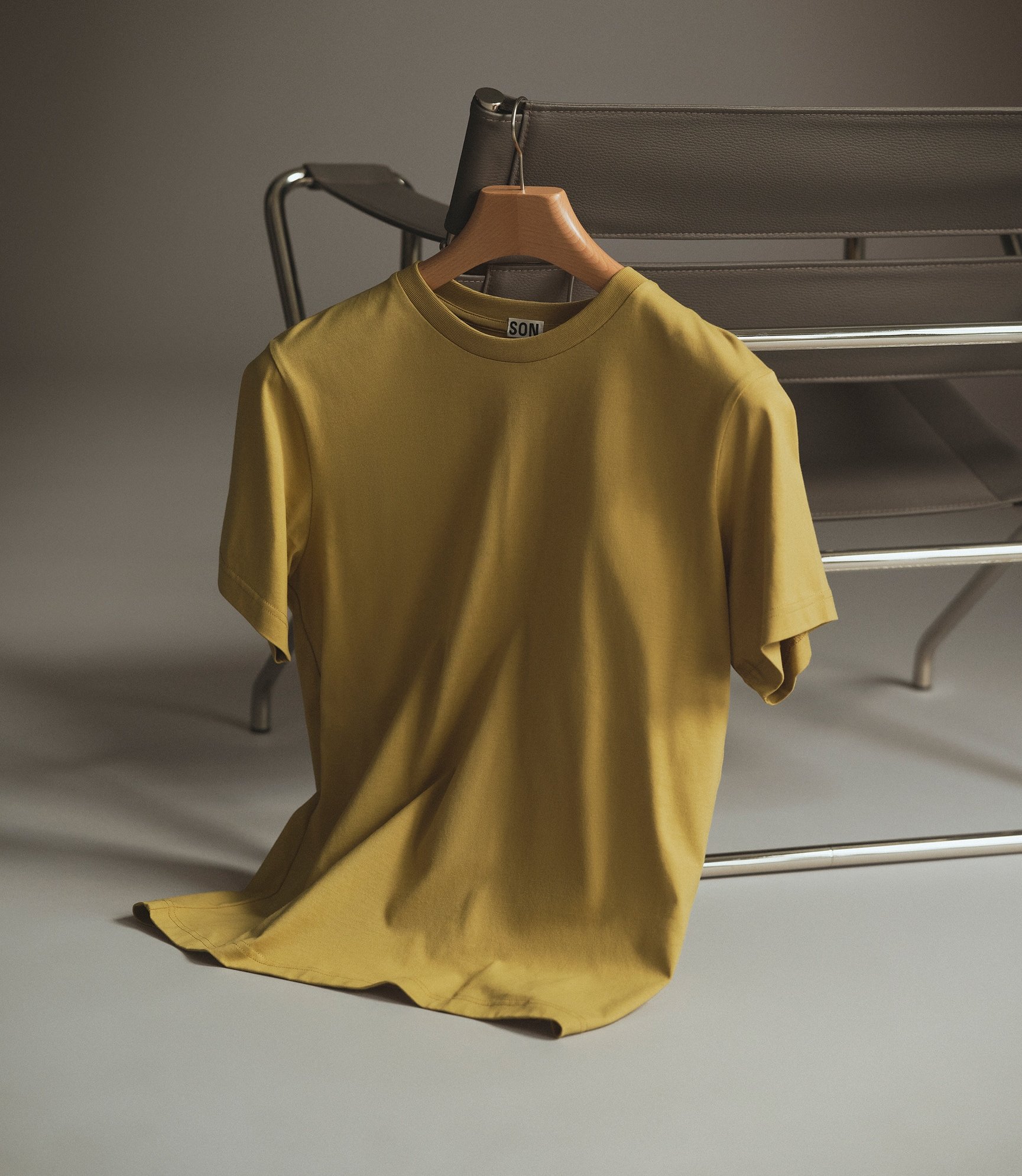 Cotton t-shirt in khaki hanging off a chair