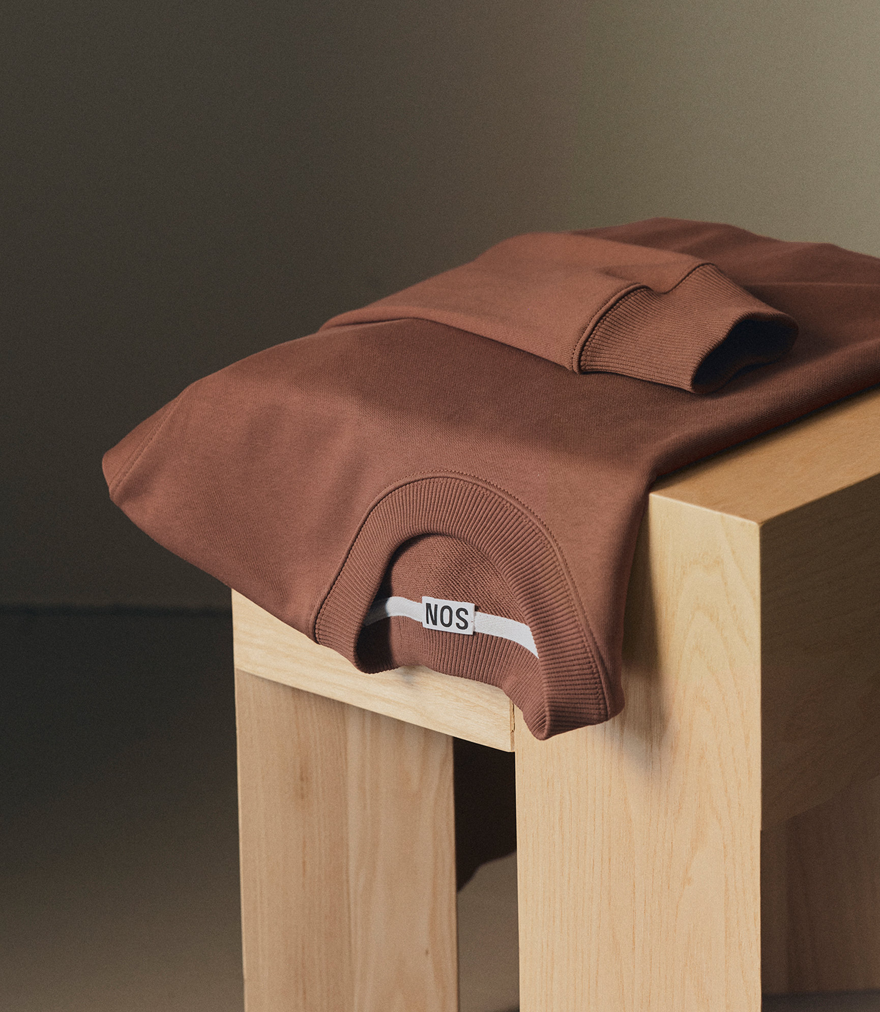 Our cotton sweatshirt in mink over a stool