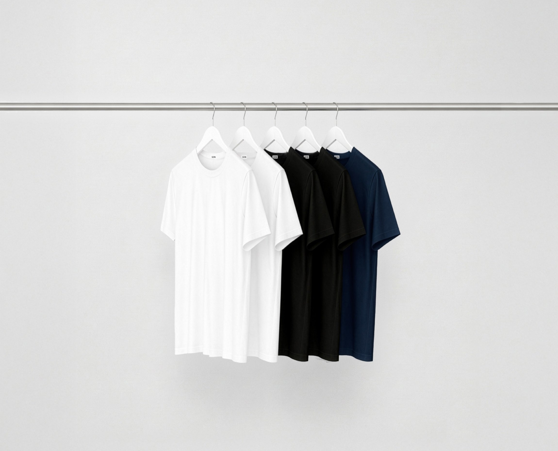Mix essentials bundle t-shirts hanging on a rack against a grey background