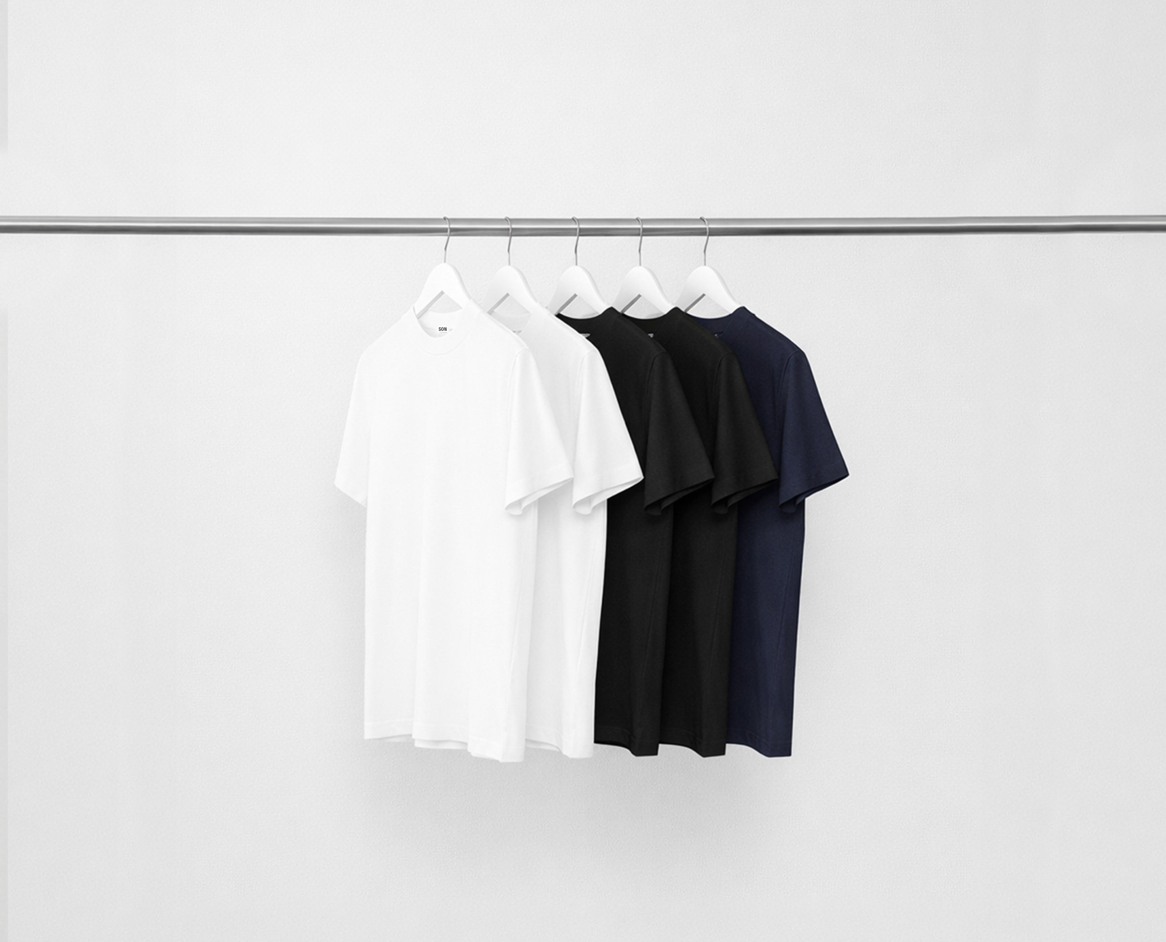 Mix Hi-Necks bundle t-shirts hanging on a rack against a grey background